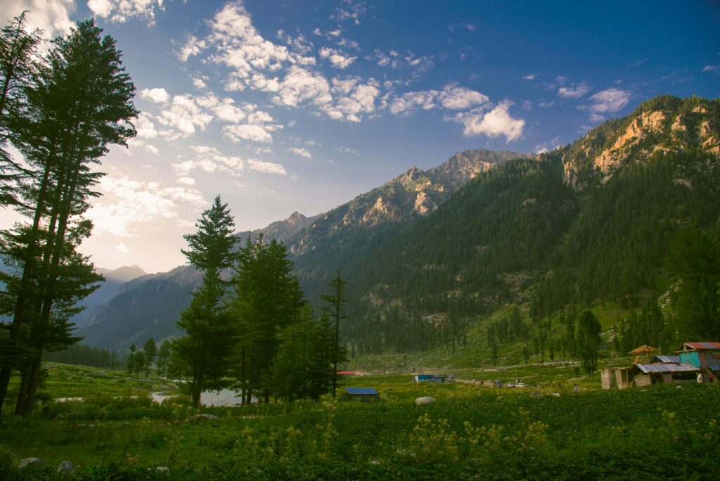 Breathtaking view of Kumrat Valley's lush green mountains and tranquil valley at dawn.