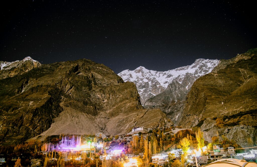 Majestic starry night over the illuminated mountains of Karimabad, capturing nature's beauty.